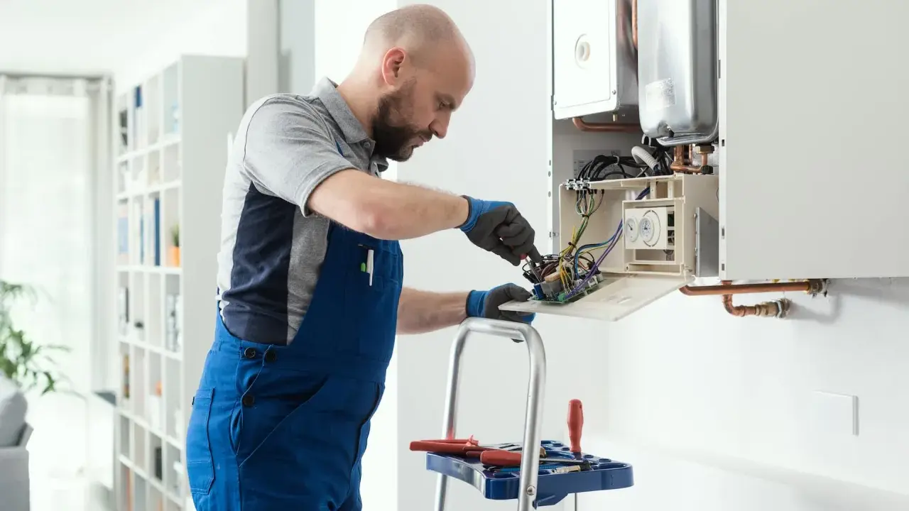 Técnico revisa el cableado interno de una caldera, mostrando cómo funciona.
