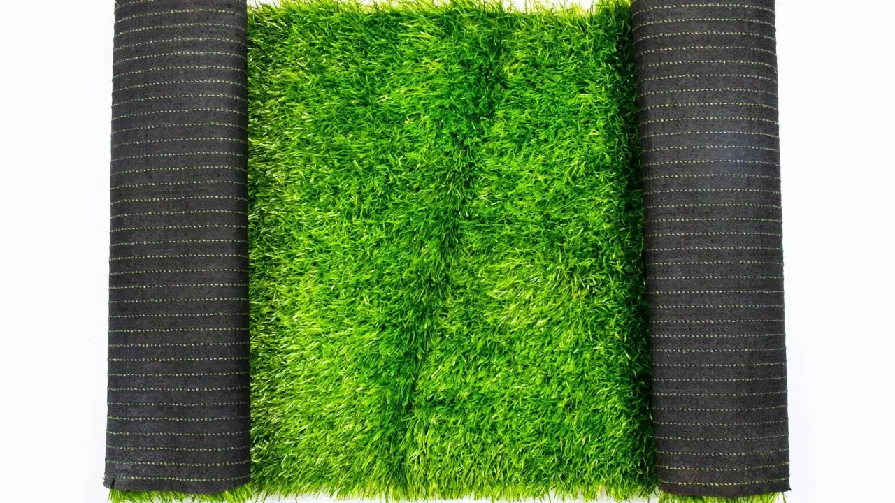 Rollo de césped artificial verde brillante, listo para peinar y colocar.