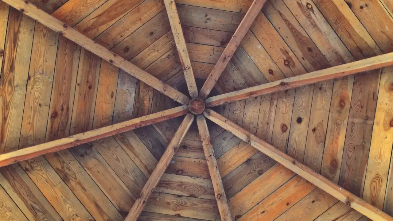 Estructura radial de vigas de madera que se unen en el centro, formando unos techos de madera rústicos y acogedores.