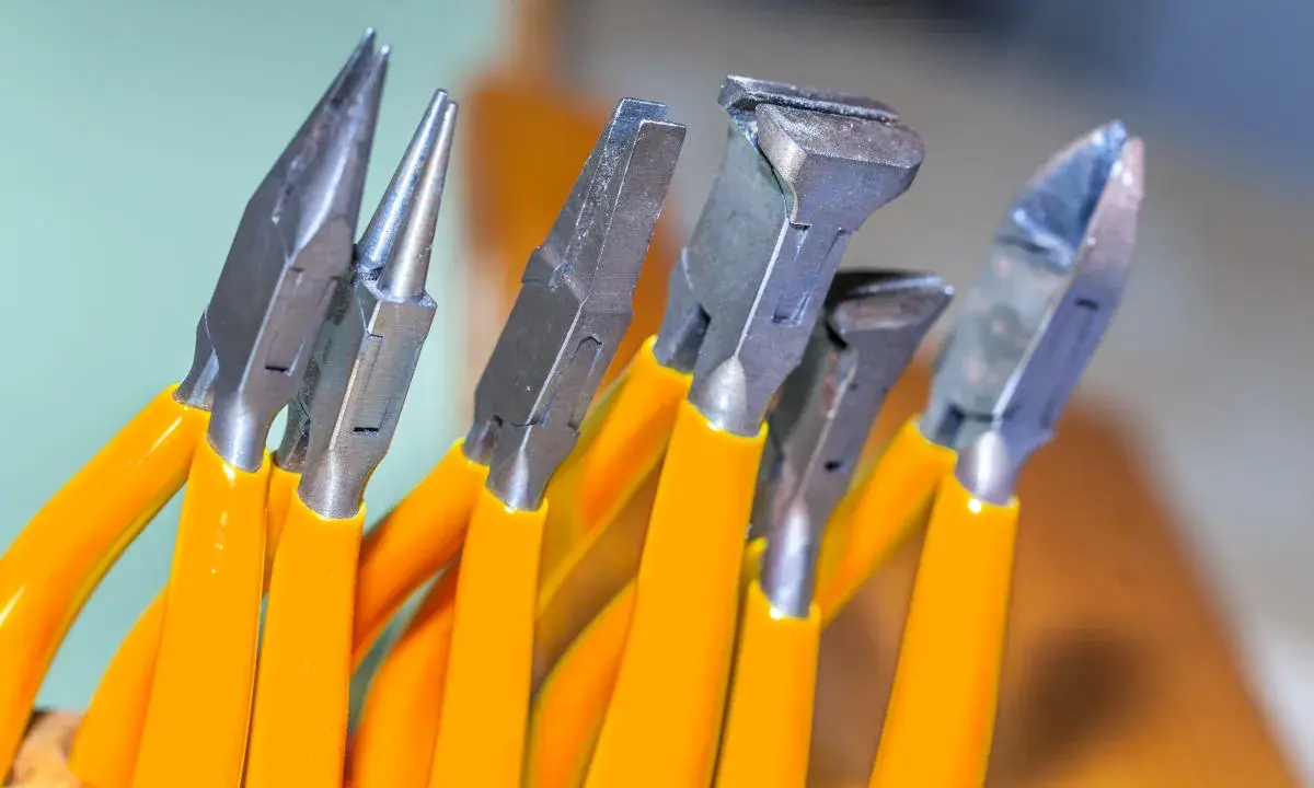 Variedad de tipos de alicate con mangos naranjas, listos para cualquier tarea de bricolaje o joyería.