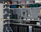 Estanterías metálicas con cajas, herramientas, botas de agua y otros objetos, ideales para saber como organizar un trastero de forma eficiente.