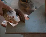 Mano sujetando una radial para cortar azulejos con precisión.