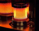 Estufa de parafina encendida, con llama naranja y azul visible a través de perforaciones. Pros y contras de su uso.