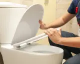 Man installing a toilet with horizontal outlet.
