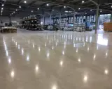 Almacén con suelo de hormigón pulido, ideal para el tratamiento de litio. Estanterías metálicas y palets de madera.