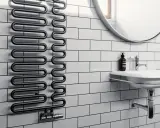 Radiador toallero negro con diseño ondulado, ideal para secar toallas o calentar el baño. Un radiador normal con estilo.