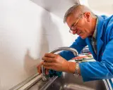 Fontanero con gafas trabajando en el fregadero para cambiar grifo cocina.