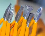 Variedad de tipos de alicate con mangos naranjas, listos para cualquier tarea de bricolaje o joyería.