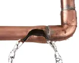 Tubería de cobre rota con agua saliendo. Es hora de arreglar tubería picada.