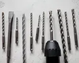 Variedad de tipos de mandriles para taladros, incluyendo brocas para concreto y un cincel, listos para cualquier trabajo.