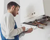Técnico revisa caldera de gas, asegurando el cumplimiento de la normativa calderas de gas en viviendas.