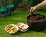 Persona añade tierra a un compostador al aire libre. Hay restos de comida y un cortacésped en el jardín.