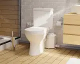 Moderno baño con inodoro triturador, lavabo de madera y ducha. Opiniones positivas sobre su eficiencia.