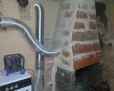 Instalación de tubos flexibles para estufa de leña, conectando a la chimenea de ladrillo.