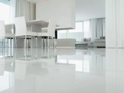 Un moderno salón con un impecable suelo resina epoxi vivienda, reflejando la luz y el mobiliario minimalista.