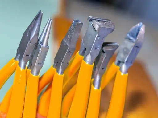 Variedad de tipos de alicate con mangos naranjas, listos para cualquier tarea de bricolaje o joyería.