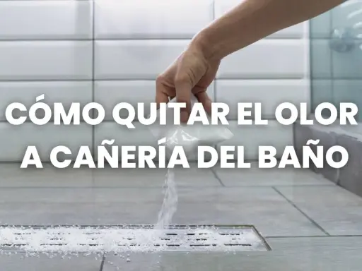Mano esparciendo gránulos blancos en un desagüe de ducha para eliminar el olor a tuberías del baño.