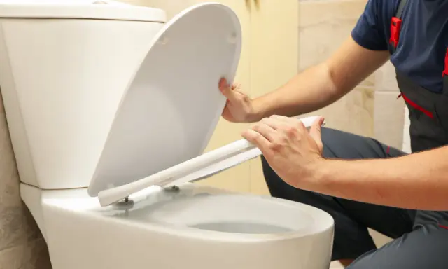 Man installing a toilet with horizontal outlet.