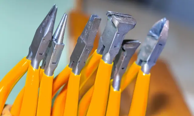 Variedad de tipos de alicate con mangos naranjas, listos para cualquier tarea de bricolaje o joyería.