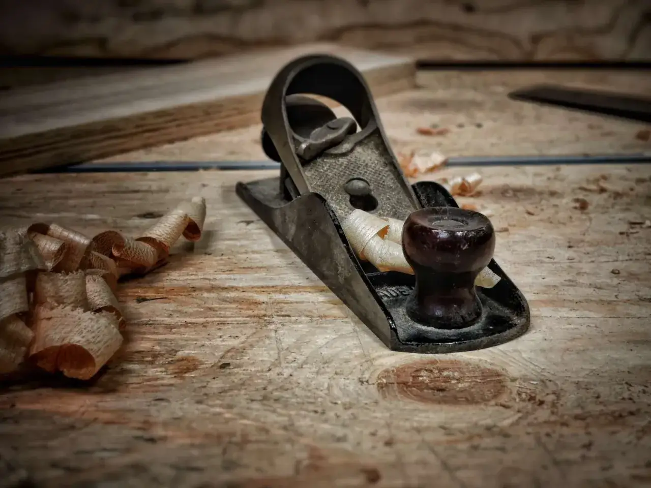 Cepillo de carpintero y virutas de madera, herramientas de acabado esenciales para dar forma y suavidad a la madera.