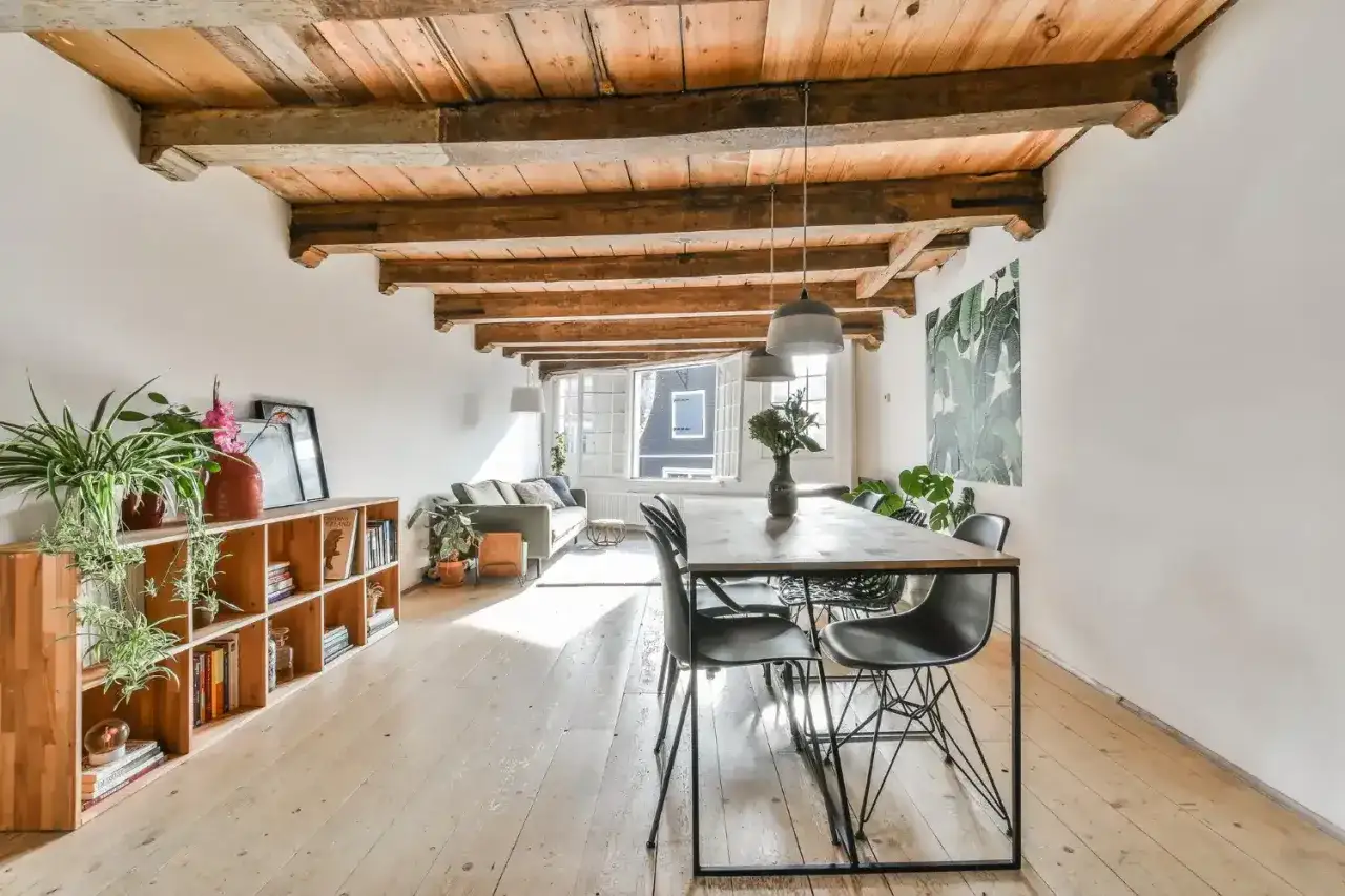 Amplio sal&oacute;n con vigas de madera expuestas en los techos, muebles modernos y mucha luz natural.