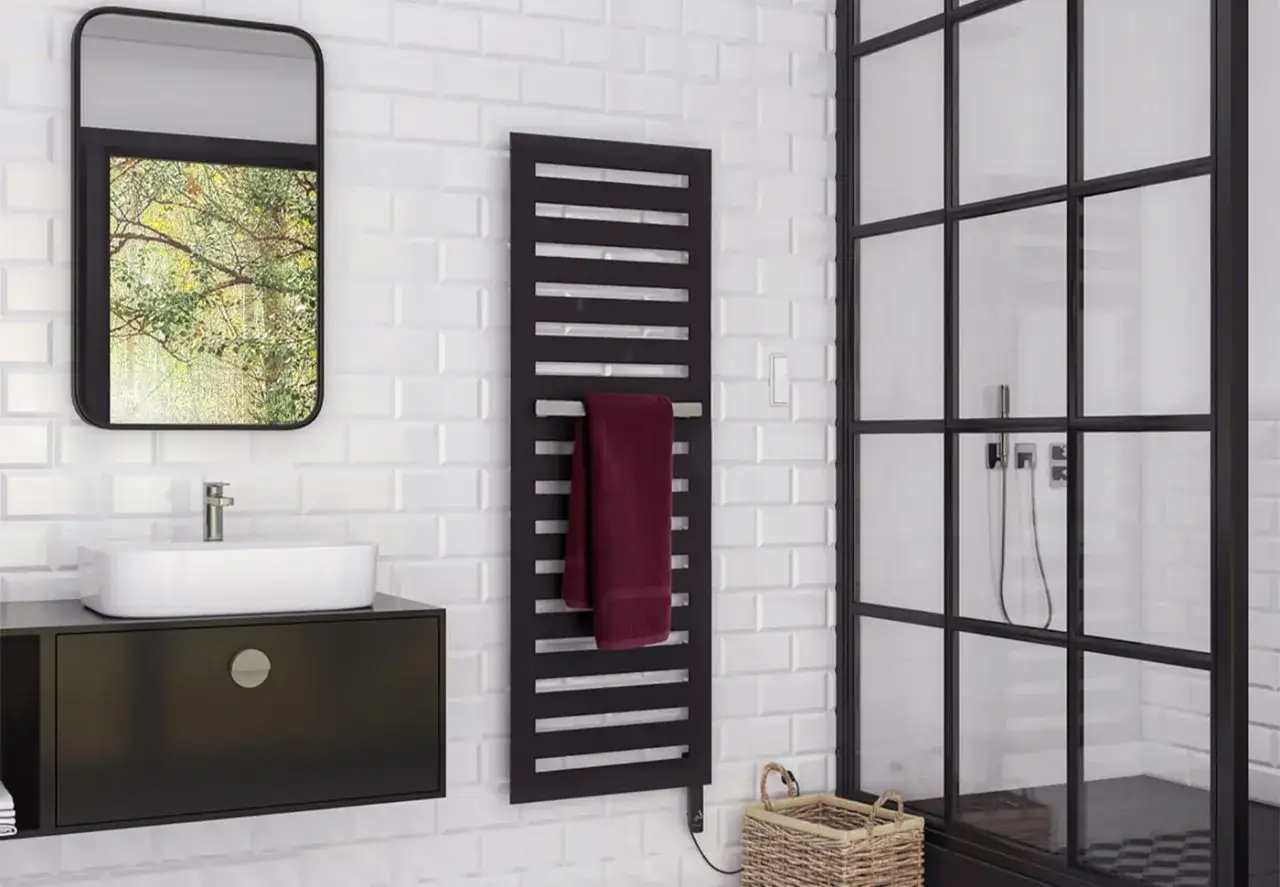 Radiador toallero negro, ideal para colocar junto a la ducha o el lavabo, manteniendo tus toallas calientes y secas.