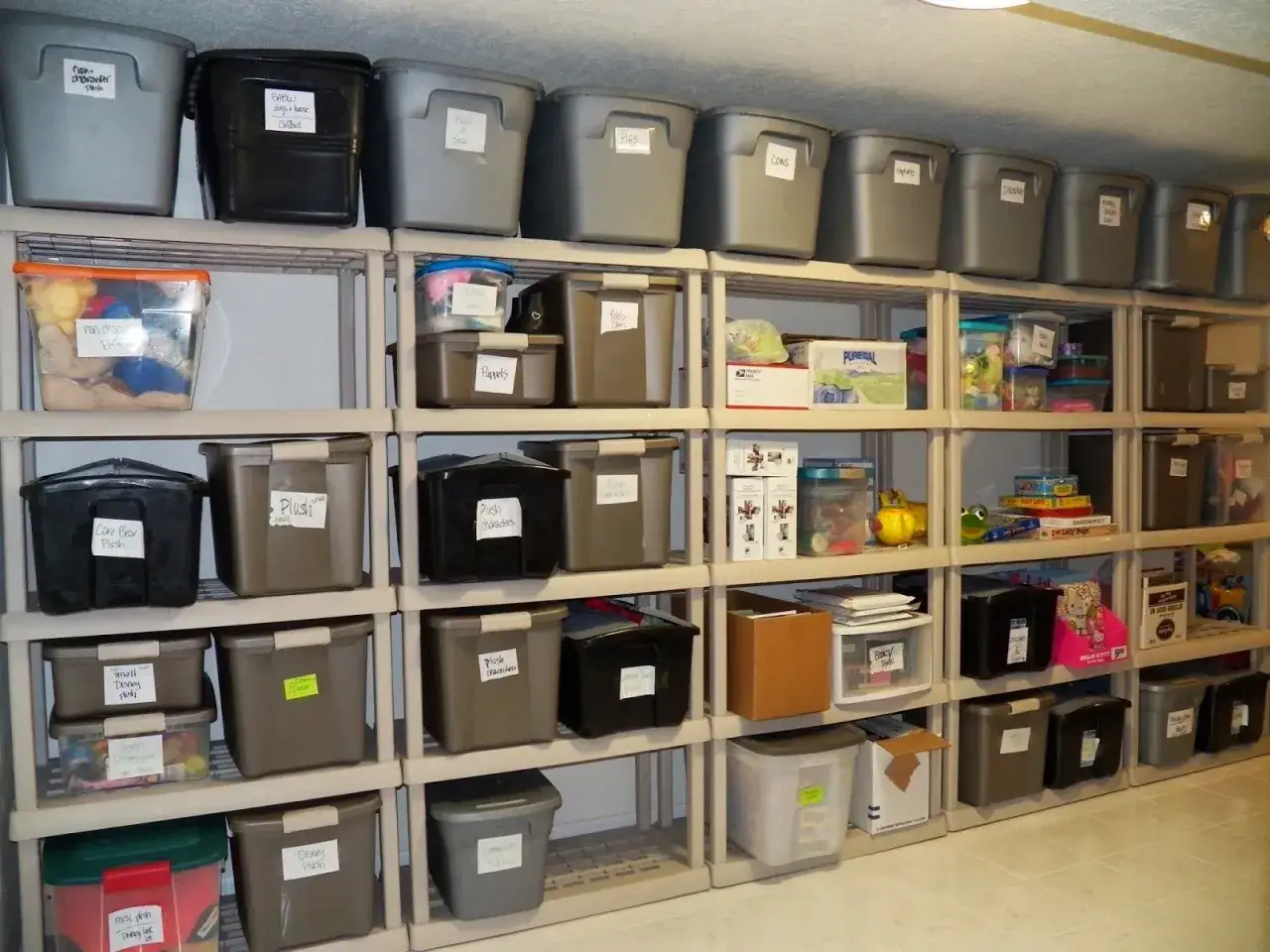 Estanter&iacute;as llenas de cajas pl&aacute;sticas etiquetadas, un ejemplo de c&oacute;mo organizar un trastero para tener todo a mano.