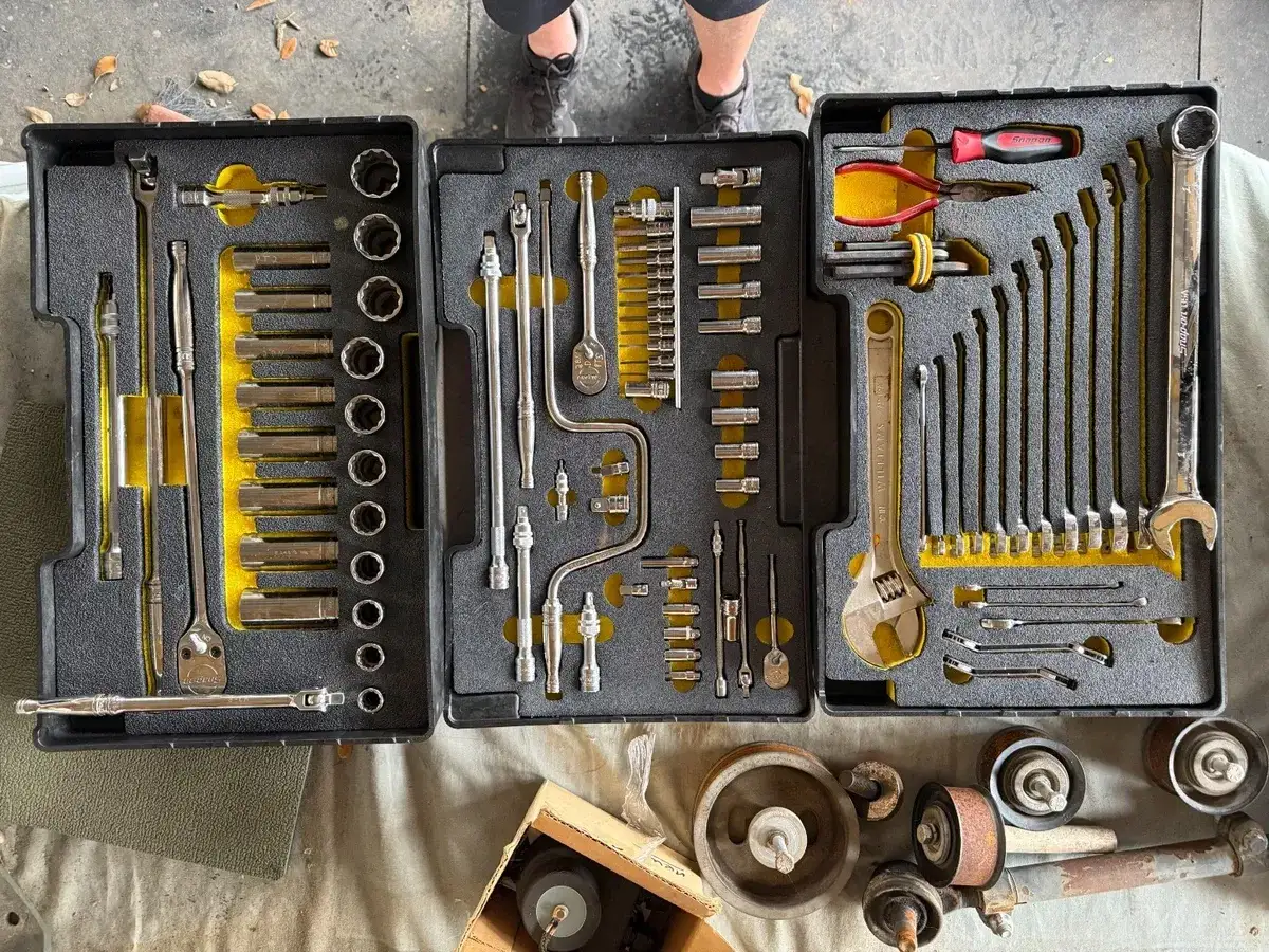 Caja de herramientas con varios tipos de llaves, dados, matraca y alicates.