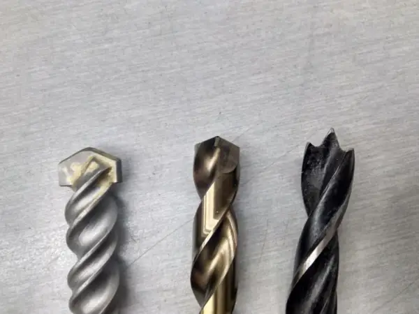 Tres brocas diferentes: una para mampostería, una para metal y una para madera. Cada broca tiene un diseño único para su propósito.